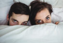 Portrait of happy couple having fun in bedroom at home